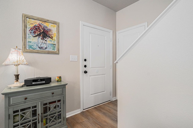 foyer entrance with dark wood finished floors and baseboards