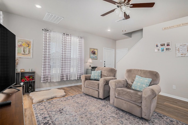 living area with baseboards, visible vents, wood finished floors, and recessed lighting