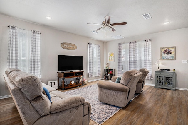 living room with visible vents, ceiling fan, and wood finished floors