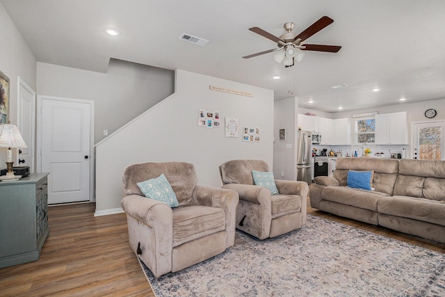 living room featuring baseboards, visible vents, a ceiling fan, wood finished floors, and recessed lighting