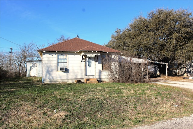 view of front of home with cooling unit, a front lawn, and a carport