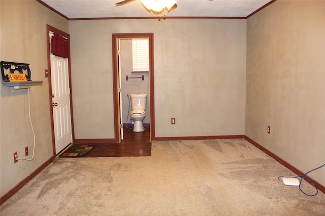 unfurnished room with ornamental molding, carpet, and ceiling fan