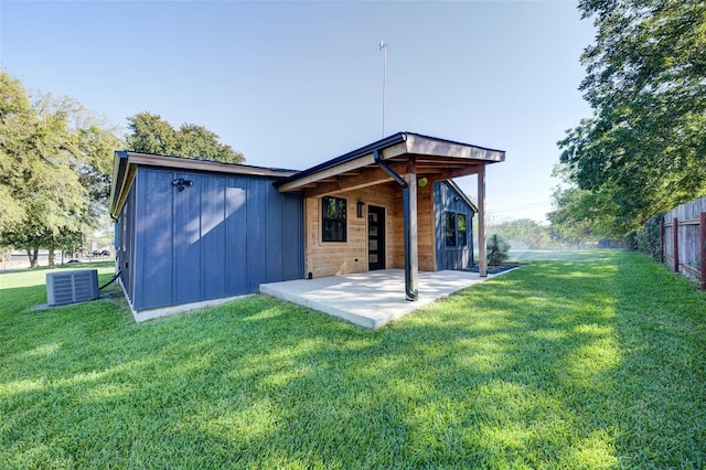 rear view of house with a yard, central AC, and a patio area