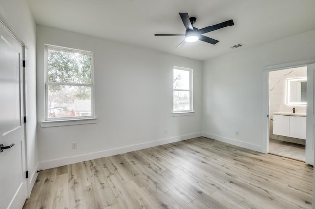 unfurnished bedroom featuring connected bathroom and light hardwood / wood-style flooring