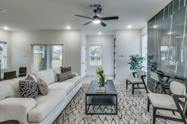 living room featuring ceiling fan, hardwood / wood-style floors, and a wealth of natural light