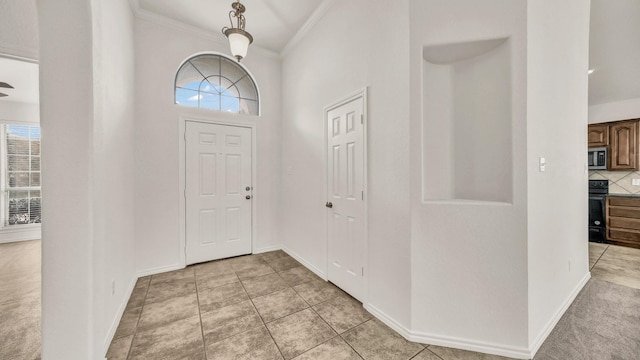 entrance foyer with light tile patterned floors and ornamental molding