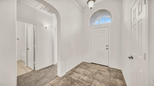 entrance foyer featuring crown molding and light tile patterned flooring