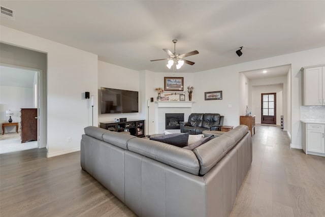 living room with ceiling fan and light wood-type flooring