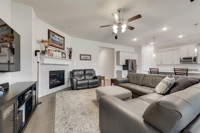 living room with ceiling fan and light hardwood / wood-style floors