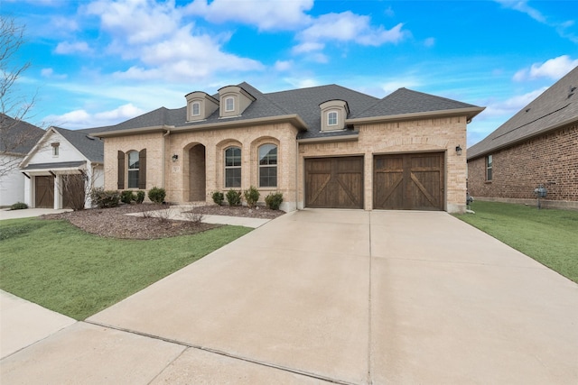 french country home featuring a garage and a front yard