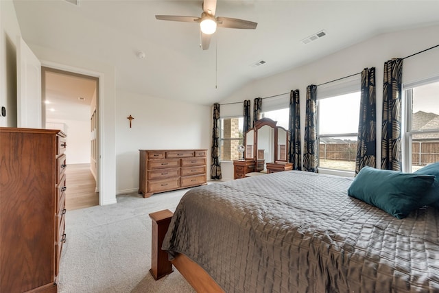 bedroom featuring multiple windows, light carpet, ceiling fan, and vaulted ceiling