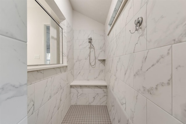 bathroom featuring tiled shower and vaulted ceiling