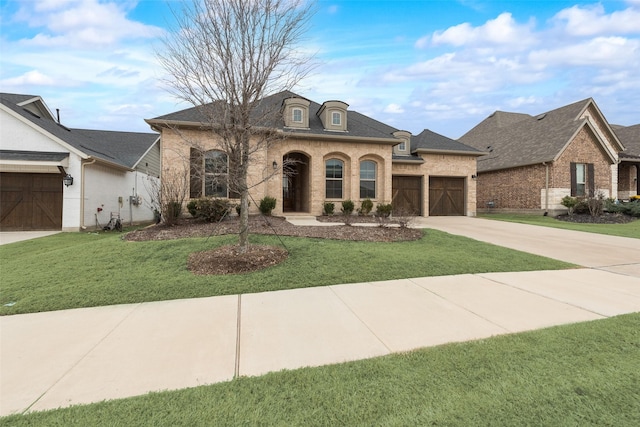 french provincial home featuring a garage and a front lawn