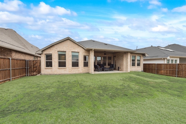 back of property with ceiling fan, a patio, and a lawn