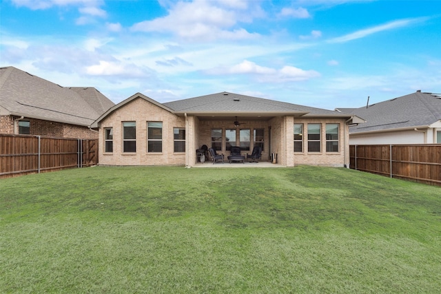 rear view of house featuring a yard, ceiling fan, and a patio area