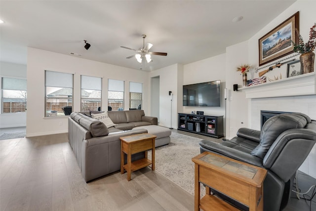 living room featuring ceiling fan, light hardwood / wood-style floors, and a healthy amount of sunlight