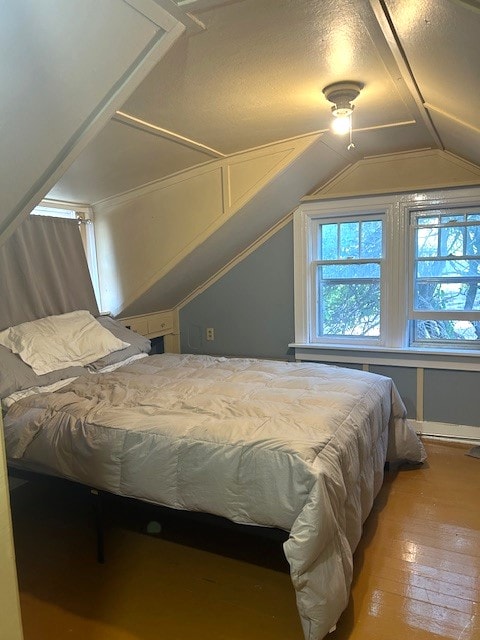 bedroom with vaulted ceiling and wood-type flooring