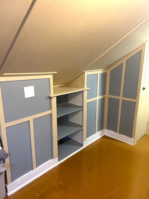 bonus room featuring wood-type flooring and vaulted ceiling