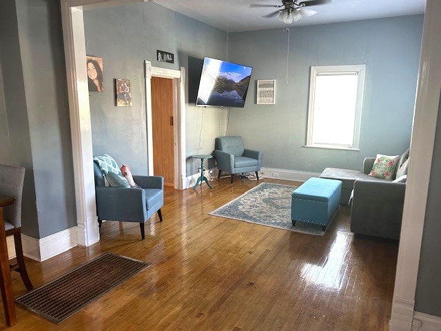 living room featuring hardwood / wood-style floors and ceiling fan