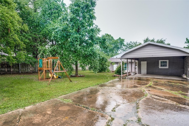 exterior space featuring a playground, a carport, and a front lawn