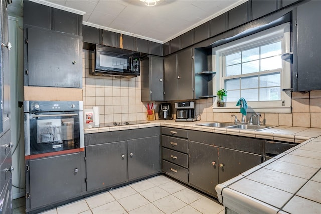 kitchen featuring ornamental molding, decorative backsplash, tile countertops, and black appliances