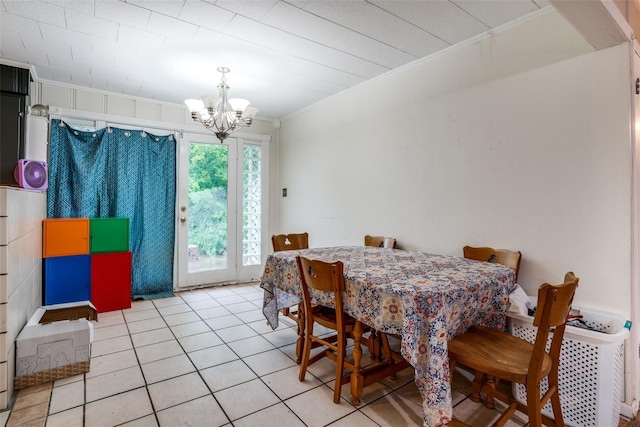 dining space featuring light tile patterned floors, crown molding, and a chandelier