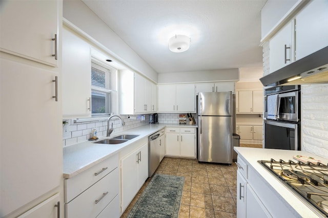 kitchen featuring sink, backsplash, stainless steel appliances, and white cabinets