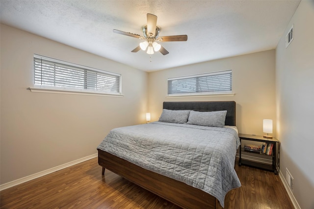 bedroom featuring a textured ceiling, dark hardwood / wood-style floors, and ceiling fan