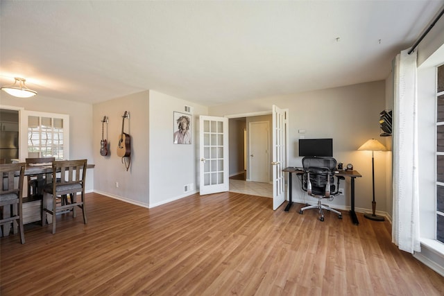 office featuring light hardwood / wood-style floors and french doors