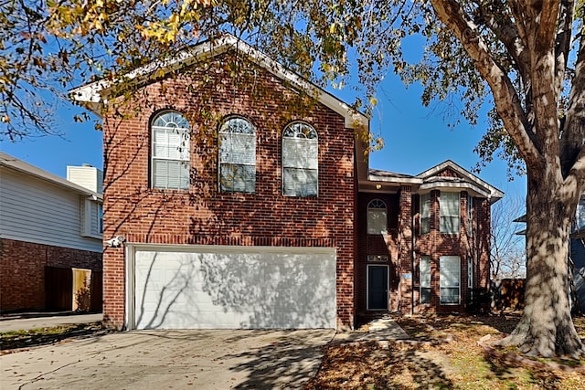 view of front of property featuring a garage, concrete driveway, and brick siding