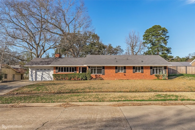 ranch-style home with concrete driveway, a front lawn, an attached garage, and brick siding