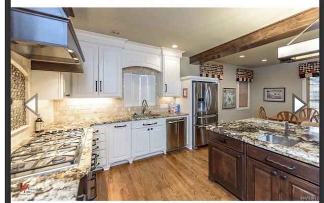 kitchen with white cabinetry, appliances with stainless steel finishes, sink, and light stone countertops