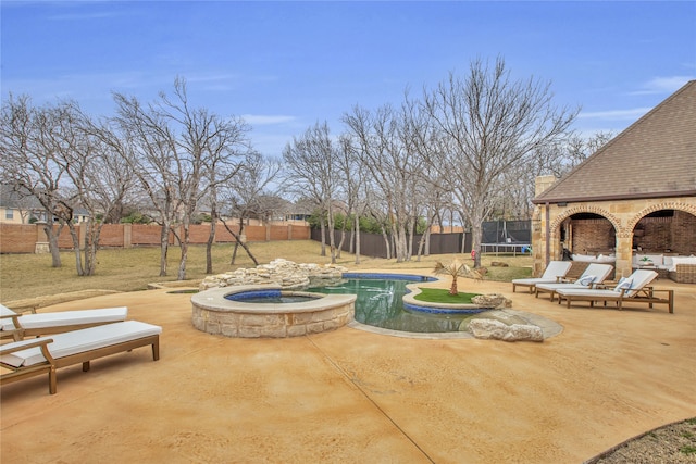 view of patio / terrace with a swimming pool with hot tub and a trampoline