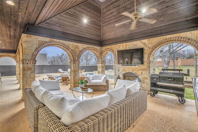 view of patio / terrace featuring ceiling fan and an outdoor living space with a fireplace