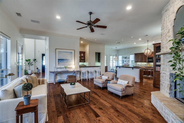 living room featuring ornamental molding, dark hardwood / wood-style floors, and ceiling fan