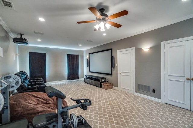 home theater room with ornamental molding, carpet floors, and ceiling fan