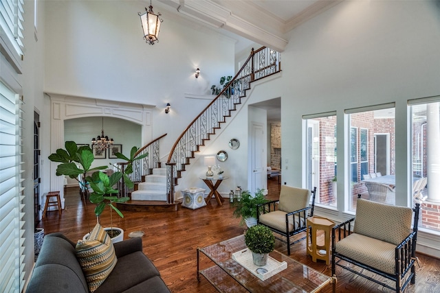 living room featuring a healthy amount of sunlight, dark hardwood / wood-style floors, and crown molding