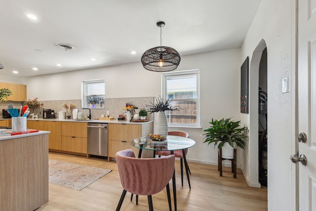 9704 Lanward Dr, Dallas, TX 75238 - kitchen with decorative light fixtures, light hardwood / wood-style flooring, light brown cabinets, dishwasher, and backsplash