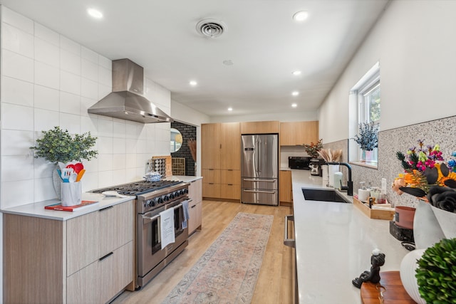 9704 Lanward Dr, Dallas, TX 75238 - kitchen featuring wall chimney exhaust hood, sink, light hardwood / wood-style flooring, appliances with stainless steel finishes, and backsplash