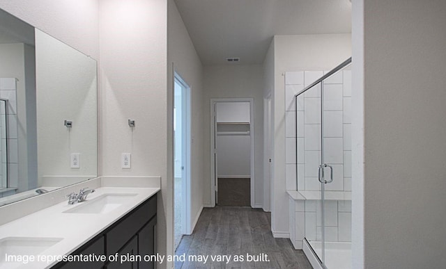 bathroom with hardwood / wood-style flooring, vanity, and a shower with shower door