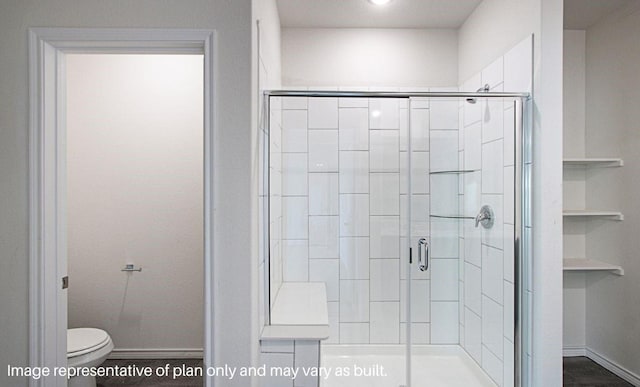 bathroom featuring an enclosed shower, built in features, and toilet