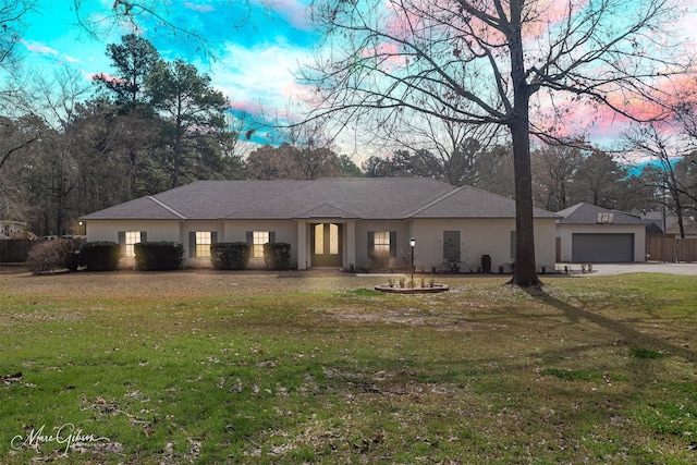 view of front of property featuring a garage and a lawn