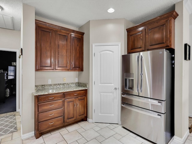 kitchen featuring light tile patterned floors, light stone counters, recessed lighting, baseboards, and stainless steel refrigerator with ice dispenser