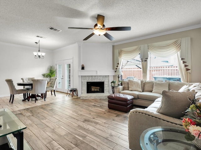 living area featuring light wood-style floors, visible vents, and a wealth of natural light