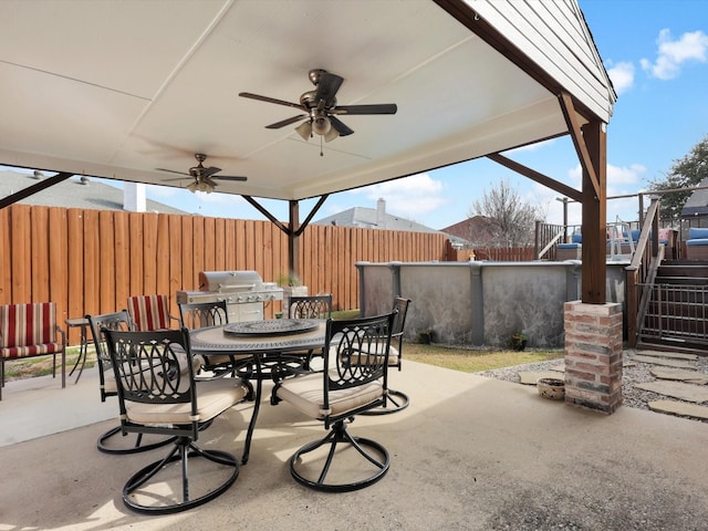 view of patio / terrace featuring ceiling fan, stairway, a grill, fence, and outdoor dining area