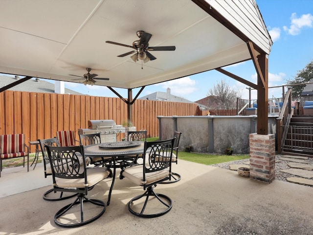 view of patio / terrace with stairway, grilling area, outdoor dining space, fence, and ceiling fan