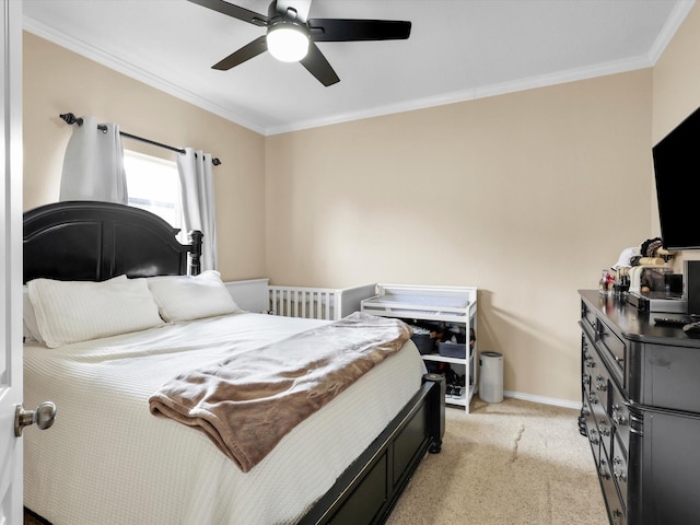 bedroom with ornamental molding, light colored carpet, baseboards, and a ceiling fan