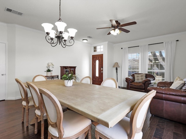 dining space with dark wood-style flooring, visible vents, and crown molding