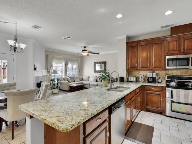 kitchen with a peninsula, appliances with stainless steel finishes, a sink, and visible vents