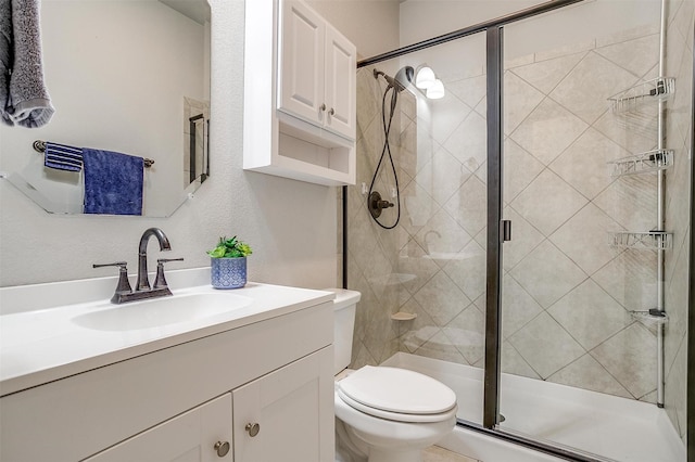 bathroom with vanity, a shower with shower door, and toilet